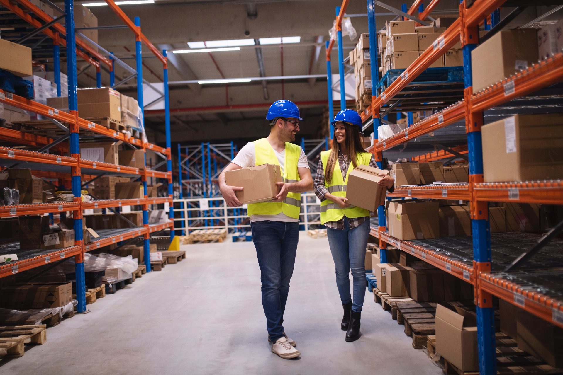 Warehouse workers carrying boxes in a storage area